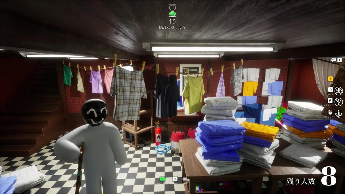 A painted Meccha Chameleon hider standing beside stacks of colorful folded laundry on a checkered floor